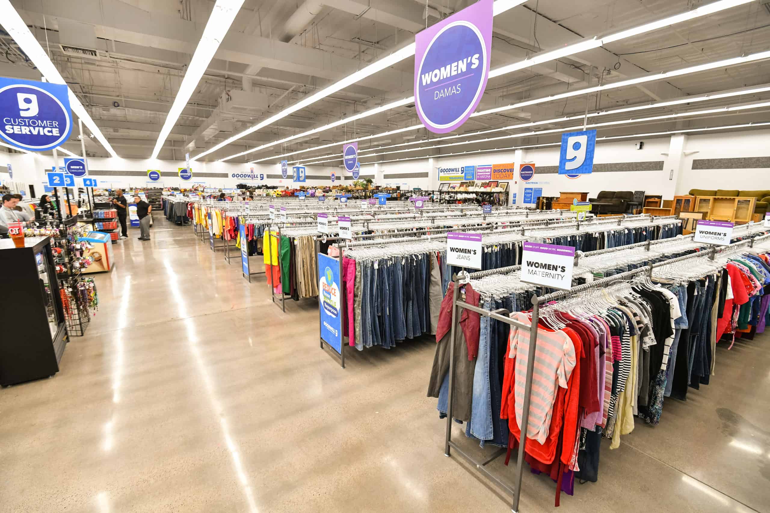 Goodwill AZ | Someone looking through racks of white shirts on hangers