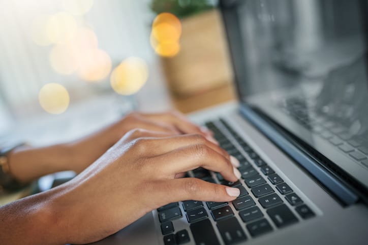 Goodwill AZ | Closeup shot of an unrecognizable woman working on a laptop at home|