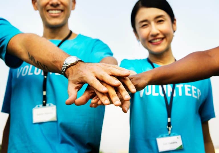 Goodwill AZ | Group of people in blue shirts putting their hands together