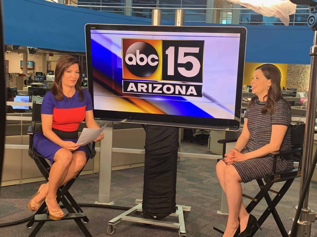 Goodwill AZ | Two news women by a TV with "ABC 15 Arizona" on screen