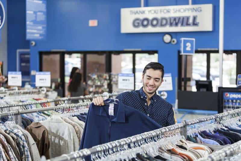 Goodwill AZ | Man looking at a blue shirt in the store