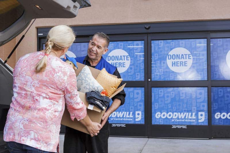 Goodwill AZ | Women passing a box to a man