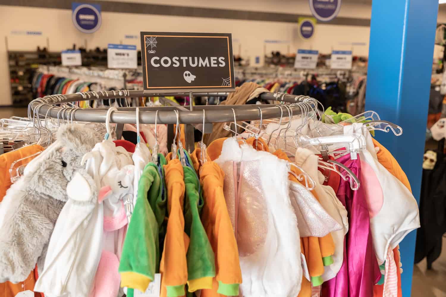 Goodwill AZ | Someone looking through racks of white shirts on hangers