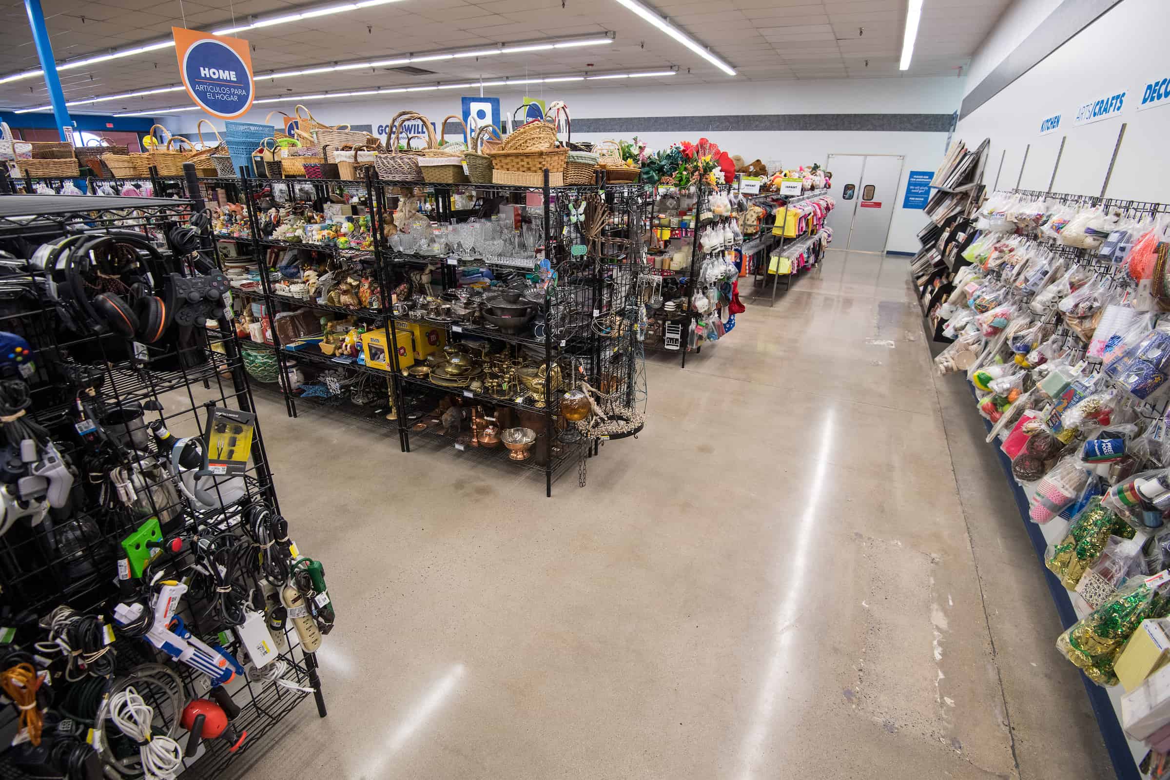 Goodwill AZ | Someone looking through racks of white shirts on hangers