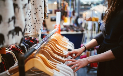 Goodwill AZ | someone looking at white shirts on hangers