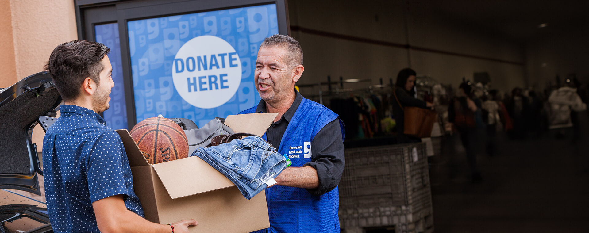 someone donating a box of items to a Goodwill donation drop off location